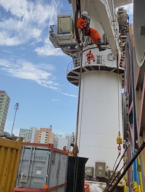 Técnico em acesso por corda na coluna de um guindaste em Vitória, ES